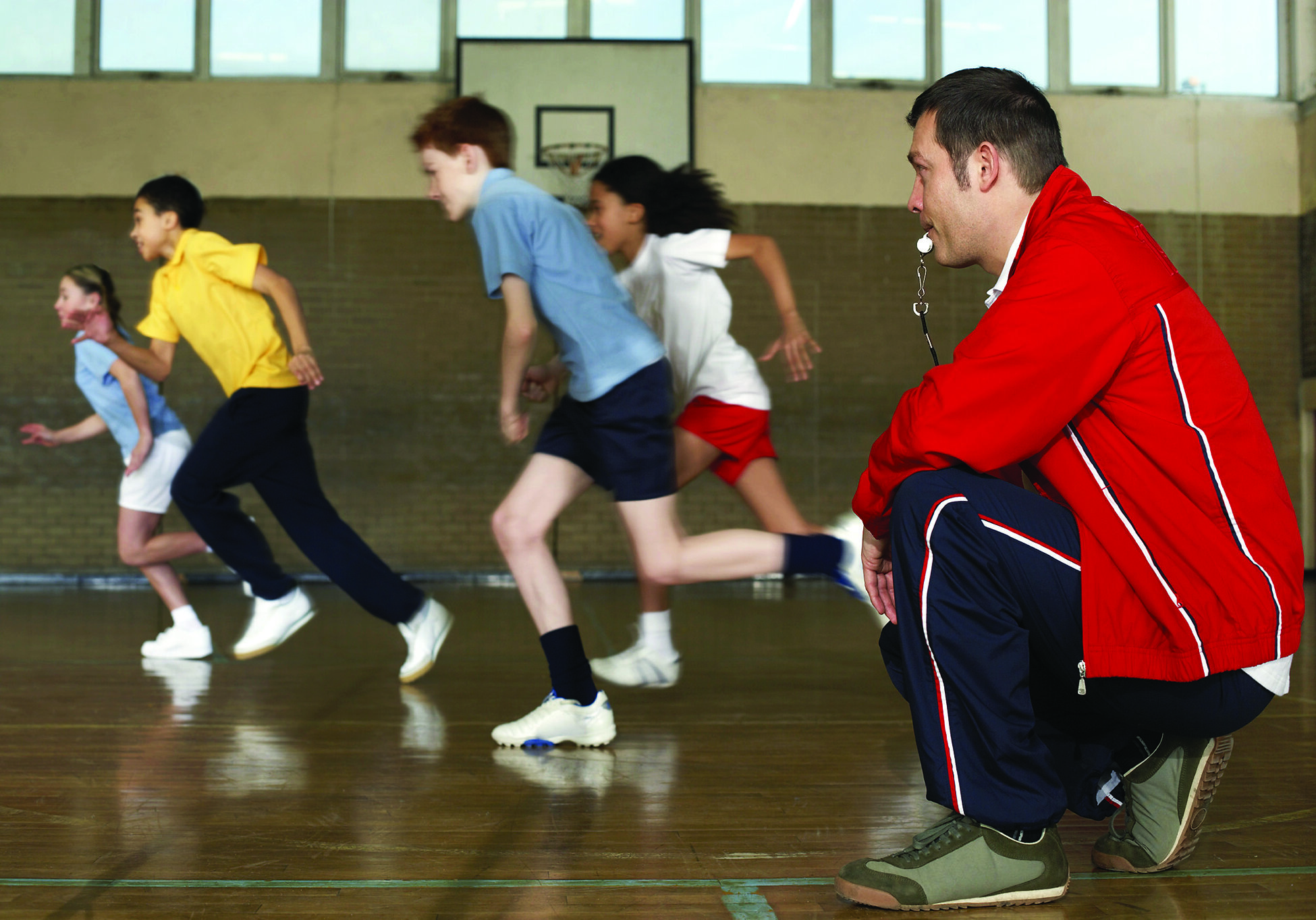 Teacher and students in a gymnasium.