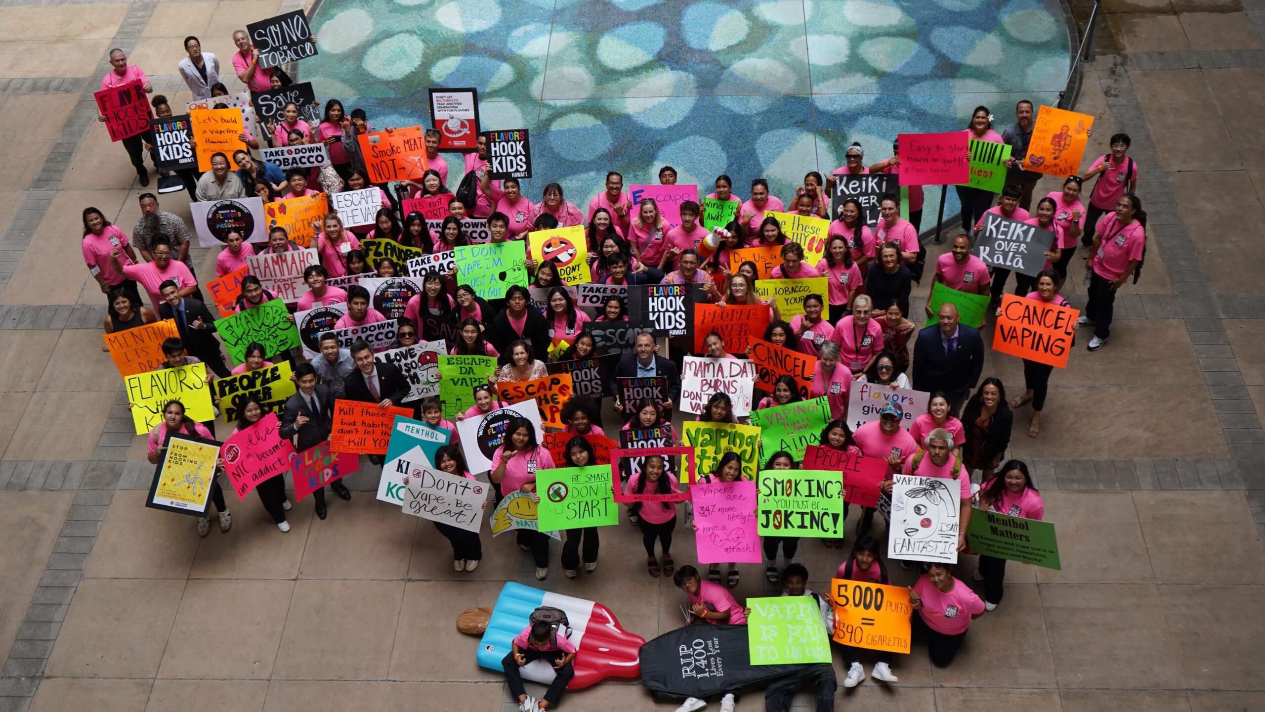 A group of people holding signs and being photographed from up above.